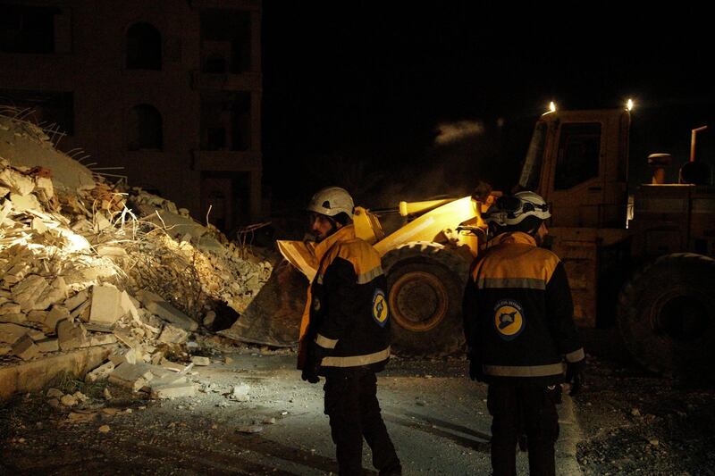epa06496987 Syrian civil defense volunteers walk next to a bulldozer near civilian buildings which were destroyed in airstrikes in in Idlib City, Syria, 04 February 2018. The number of killed and wounded is unclear. According to activists the airstrikes were conducted by Russian warplanes.  EPA/YAHYA NEMAH