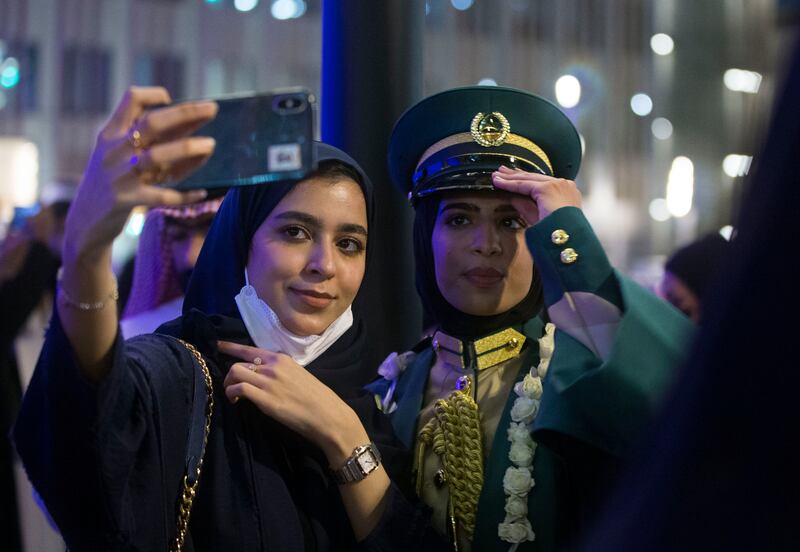 A new graduate takes a photo at Al Wasl Dome.