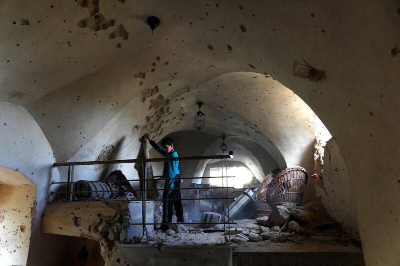 A boy is seen inside a damaged house where a Palestinian gunman was killed by Israeli forces, in Abwein village, in the Israeli-occupied West Bank. Reuters