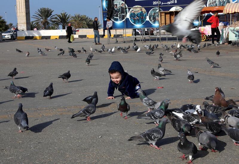 A child plays with birds at Martyrs' Square in Tripoli, Libya January 26, 2020. Reuters