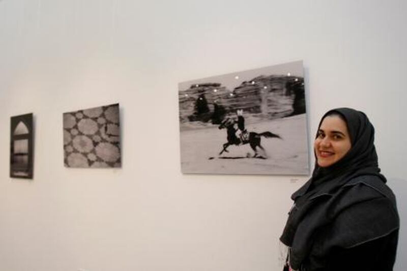 Saudi Arabian artist Rania A. Razek stands beside one of her photographs(R) titled "Bedouin" at the Gallery of Light exhibition at Dubai Community Theatre and Arts Center, February 9, 2011. Jumana El-Heloueh