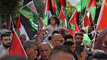 Palestinians wave the national flag during a march in the city of Ramallah in the occupied West Bank in 2022. AFP