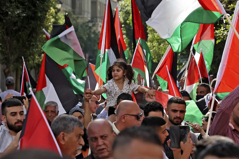 Palestinians wave the national flag during a march in the city of Ramallah in the occupied West Bank in 2022. AFP