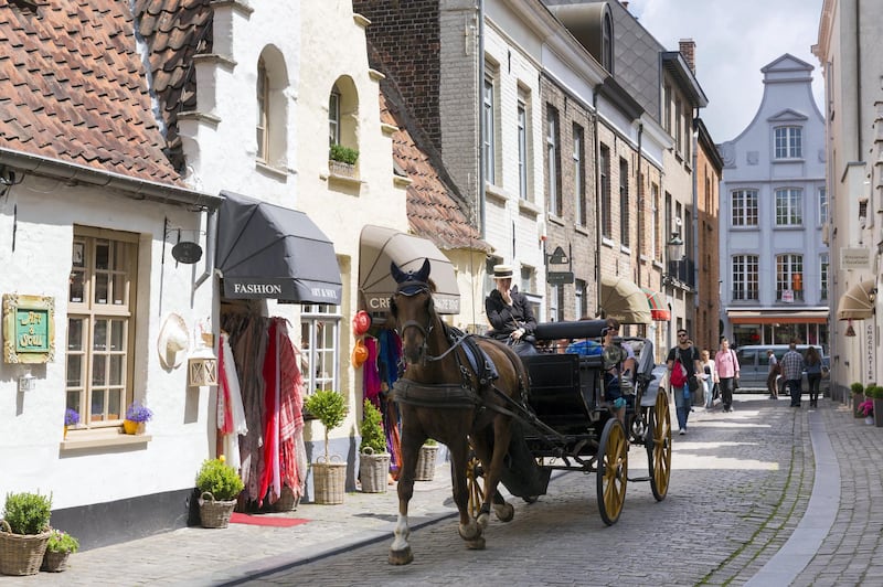 BRUGES, BELGIUM:  Tourists taking traditional horse and carriage sightseeing ride in shopping street in Bruges, Belgium.  (Photo by Tim Graham/Getty Images)
