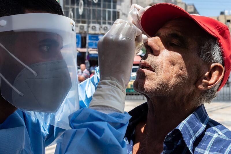 A Jordanian medic performs a coronavirus test, in front of Husseini Mosque, before the Friday prayer in central Amman, Jordan.  EPA