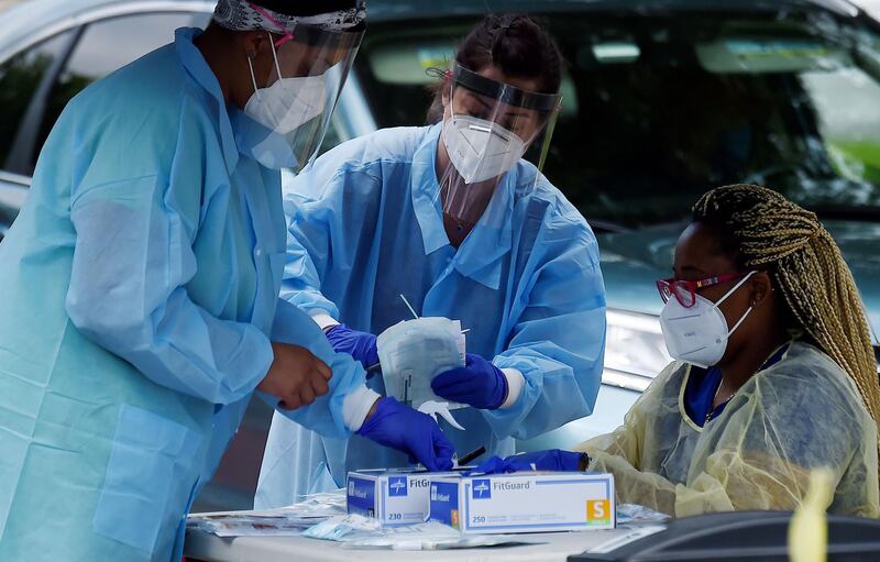 Health workers prepare to give people free Covid-19 tests without asking to show ID, doctor's note or symptoms at a drive-through and walk up Coronavirus testing centre at Barcroft Community Centre in the Arlington, Virginia. AFP