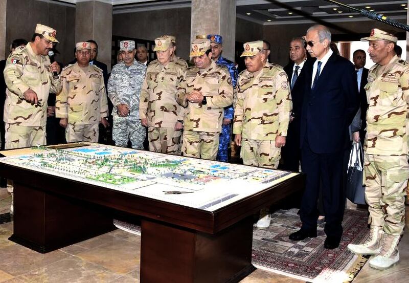 In this Sunday, Feb. 25, 2018 photo, provided by Egypt's state news agency MENA, Egyptian President Abdel-Fattah el-Sissi, center, attends the inauguration of the East Suez Canal Counter-Terrorism command, in Sinai, Egypt. Nabil Sadeq, Egypt's chief prosecutor on Wednesday, Feb. 28, 2018 reminded his staff to closely monitor the media and start legal action against any outlet that disrupts security or hurts national interests, according to a statement issued by his office. (MENA via AP)