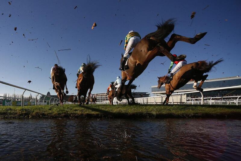 Runners clear the water jump in the Steeple Chase at Newbury Racecourse in England. Alan Crowhurst / Getty Images