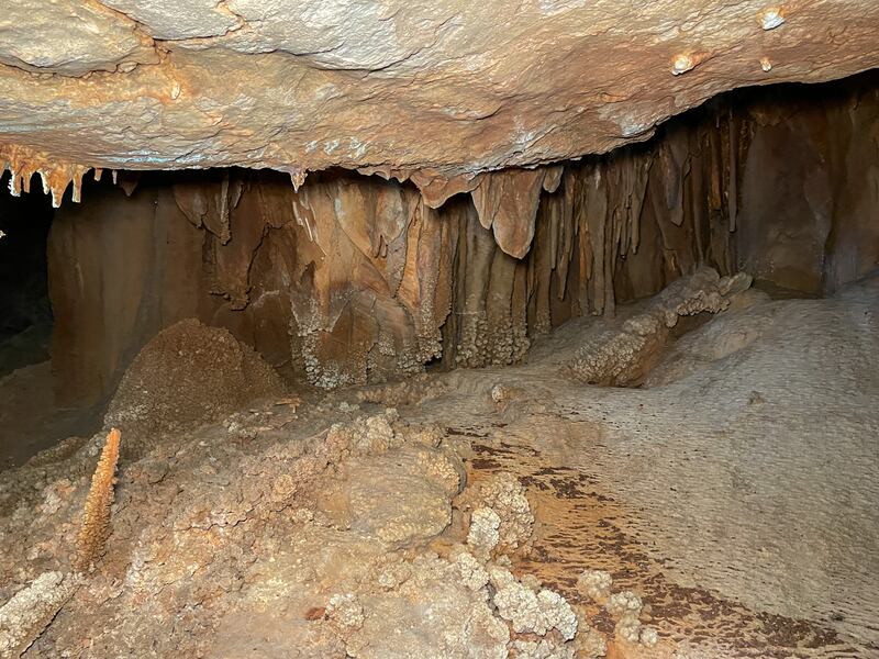 Icicle-shaped stalactites form across a cave’s ceiling.