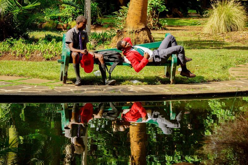 School boys relax in a park in Harare. AFP Photo