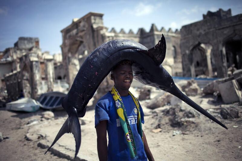 A Somali fisherman carries a swordfish to market in Mogadishu.  J M Lopez / AFP