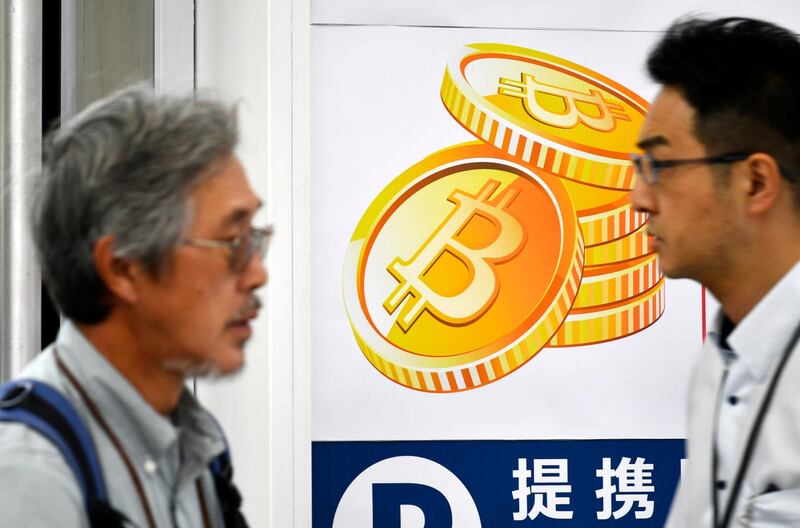 epa06476237 (FILE) - Pedestrians walk past a Bitcoin currency poster at the entrance of an electronics retailers store in central Tokyo, Japan, 01 June 2017 (reissued 26 January 2018). Reports on 26 January 2018 say Tokyo based Coincheck Inc., one of Japan’s largest bitcoin exchanges, suspended all withdrawals and trading in cryptocurrencies.  EPA/FRANCK ROBICHON