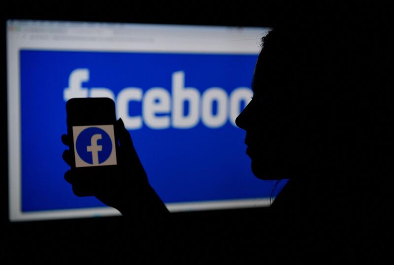 (FILES) In this file photo illustration, a smart phone screen displays the logo of Facebook on a Facebook website background, on April 7, 2021, in Arlington, Virginia Facebook said on May 26, 2021 that it has disrupted more than 150 deceptive influence schemes since 2017, with Russia the biggest single source, as culprits strive to stay "under the radar." The number of coordinated inauthentic behavior (CIB) campaigns derailed at the leading social network ramped up each year since a Russia-linked operation to sway the outcome of the 2016 US presidential election put Facebook on the defensive.
 / AFP / OLIVIER DOULIERY
