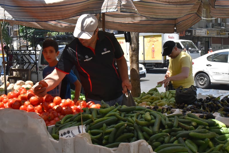 Syrians shop for vegetables at a market in Damascus on Sunday July 11, hours after Syrian President Bashar Al Assad issued a legislative decree granting civil servants and military members a 50 per cent pay rise. The decision comes a day after the government raised the price of fuel by more than 50 per cent for the third time this year. EPA