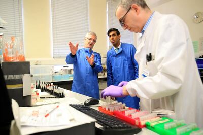 Britain's Chancellor of the Exchequer Rishi Sunak (C) is shown the testing of samples for respiratory viruses, which procedure will be used to test the novel coronavirus COVID-19, by Dr Antony Hale (L) during a visit to the pathology labs at Leeds General Infirmary to highlight the record infrastructure spend after yesterday's budget, in Leeds, Yorkshire on March 12, 2020.  / AFP / POOL / Danny Lawson
