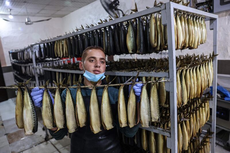 A Palestinian youth sells smoked mackerels before the Eid Al Fitr holiday, in the town of Rafah, in the southern Gaza Strip. AFP