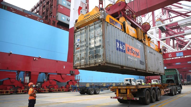 A container is loaded on to a ship at Qingdao's port in China. The country's debt is on track to hit 335 per cent of GDP, according to a new report. AP