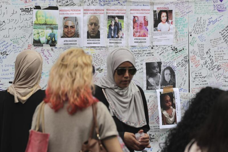 People view messages and missing persons posters at a community centre near Grenfell Tower in London, on Friday June 16, 2017. Tim Ireland / AP 