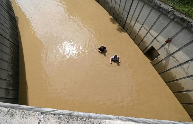 Two firefighters inspect a flooded undercrossing in Amstetten, Austria.