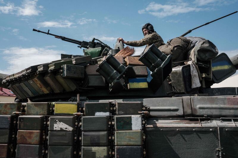 A Ukrainian tank - with a soldier in it - is carried by a transporter near Bakhmut. AFP