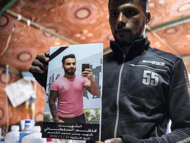 A young protester holds up a picture of a fellow demonstrator killed on the morning of January 22, 2020. Luke Pierce for The National