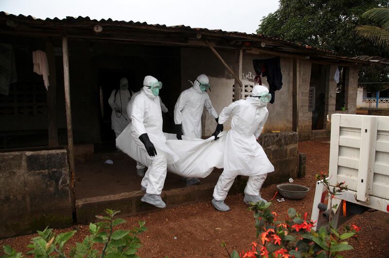 Liberian nurses carry the body of an Ebola victim from a house for burial in the Banjor Community on the outskirts of Monrovia, Liberia August 6, 2014. EPA