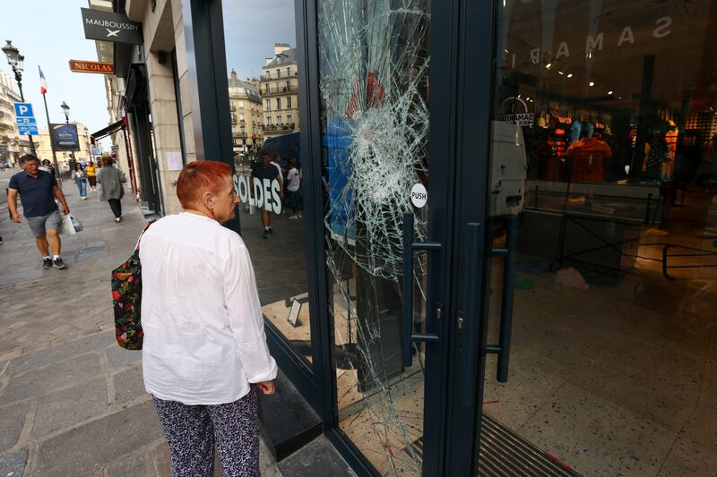 A woman looks at the damaged windows of a Jott store on Rue de Rivoli. Reuters