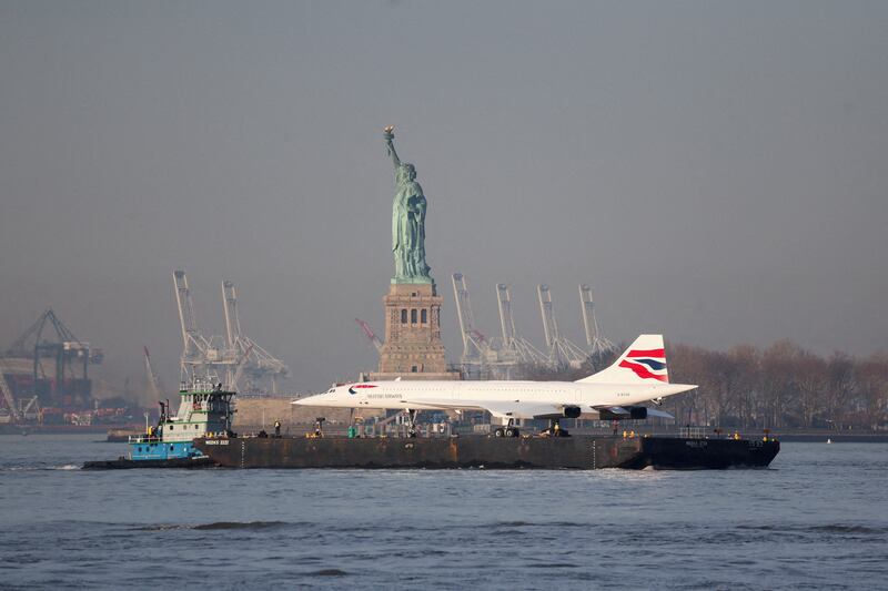 A Concorde supersonic jet is carried on a barge along the Hudson River past the Statue of Liberty, back to the Intrepid Museum in Manhattan after being refurbished at the Brooklyn Navy Yard, in New York City. Reuters