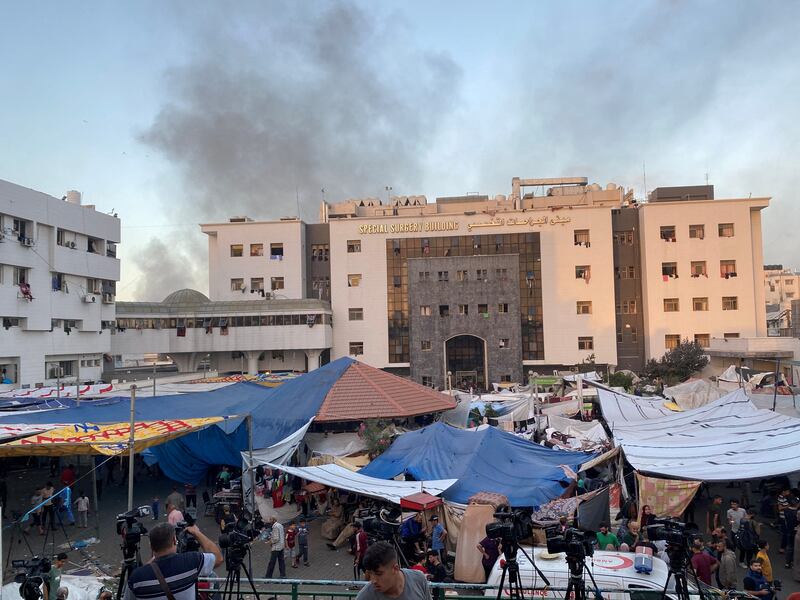 Smoke rises as displaced Palestinians take shelter at Al Shifa hospital. Reuters