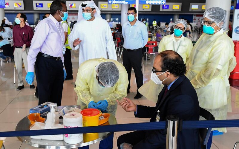 Health workers test an Indian national at the Dubai International Airport before leaving the Gulf Emirate on a flight back to his country, on May 7, 2020, amid the novel coronavirus pandemic crisis.  The first wave of a massive exercise to bring home hundreds of thousands of Indians stuck abroad was under way today, with two flights preparing to leave from the United Arab Emirates.
India banned all incoming international flights in late March as it imposed one of the world's strictest virus lockdowns, leaving vast numbers of workers and students stranded.

  


  
 / AFP / Karim SAHIB

