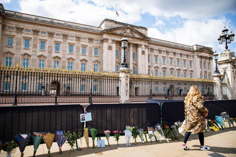 LONDON, ENGLAND - APRIL 13: People view the floral tributes to Prince Philip, Duke of Edinburgh who died at age 99 at Buckingham Palace on April 13, 2021 in London, England. The Queen announced the death of her beloved husband, His Royal Highness Prince Philip, Duke of Edinburgh. HRH passed away peacefully April 9th at Windsor Castle. (Photo by Tristan Fewings/Getty Images)