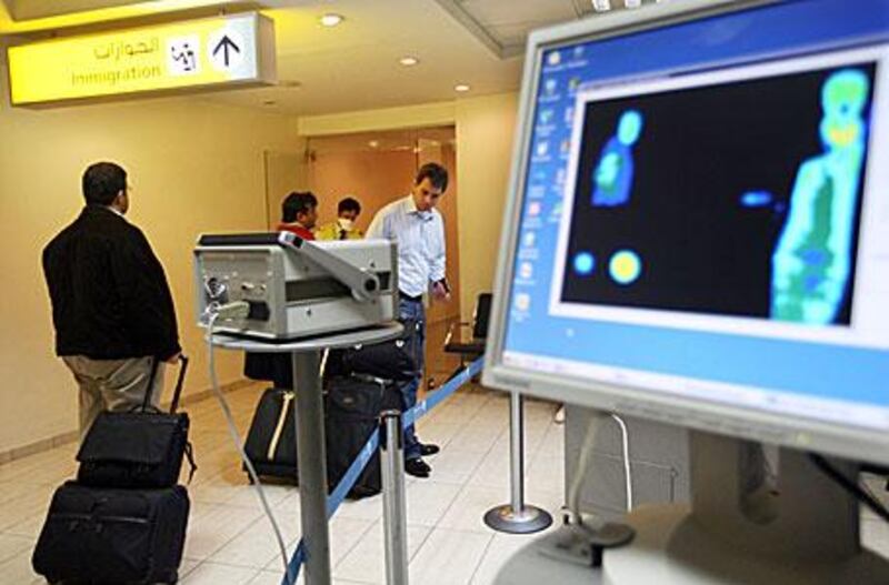 Passengers arriving at Abu Dhabi International Airport are scanned for signs of fever. There are concerns that families returning from summer holidays abroad may inadvertently bring swine flu back with them.