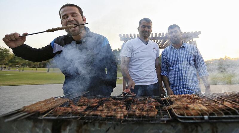 Bilal Fallaha (from left), Mohammed Fallaha and Mustafa Farhat have a family barbecue at Safa Park in Dubai on New Year’s Eve. Sarah Dea/The National