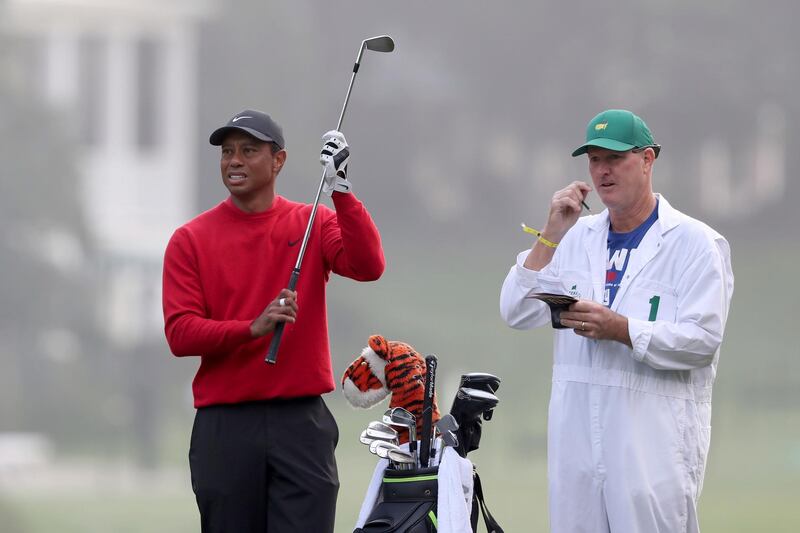 Tiger Woods prepares to hits his second shot on the first fairway with caddie Joe LaCava looking on during the final round of the Master. AP
