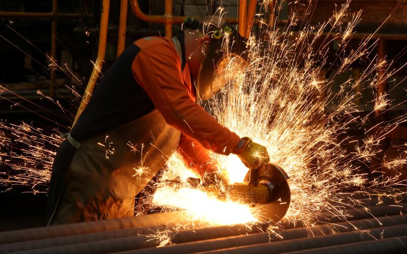A worker cuts newly manufactured bars of steel at the United Cast Bar Group's foundry in Chesterfield, Britain. Reuters