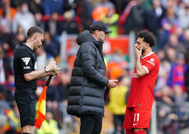 Liverpool manager Jurgen Klopp speaks to Mohamed Salah on the touchline. PA 