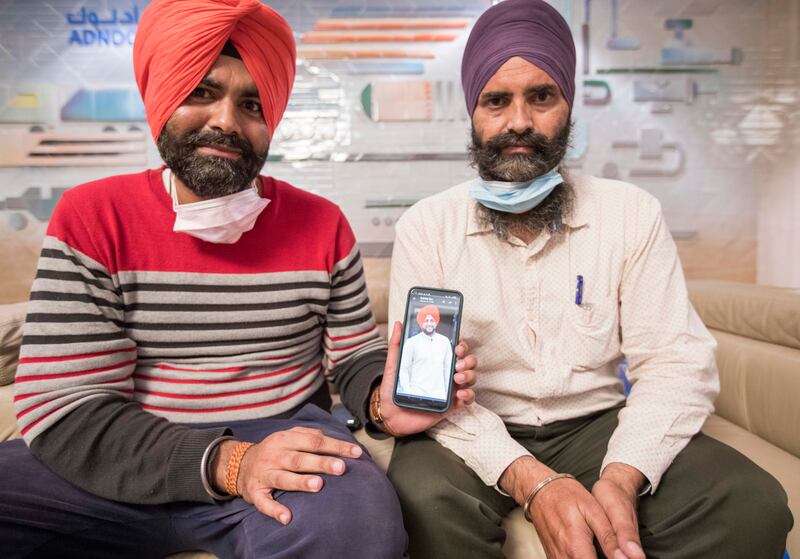 Gagandeep Singh holds up a picture of his cousin Hardeep Singh, who died in the blast. Also pictured is his second cousin Gurprit Singh. Ruel Pableo / The National