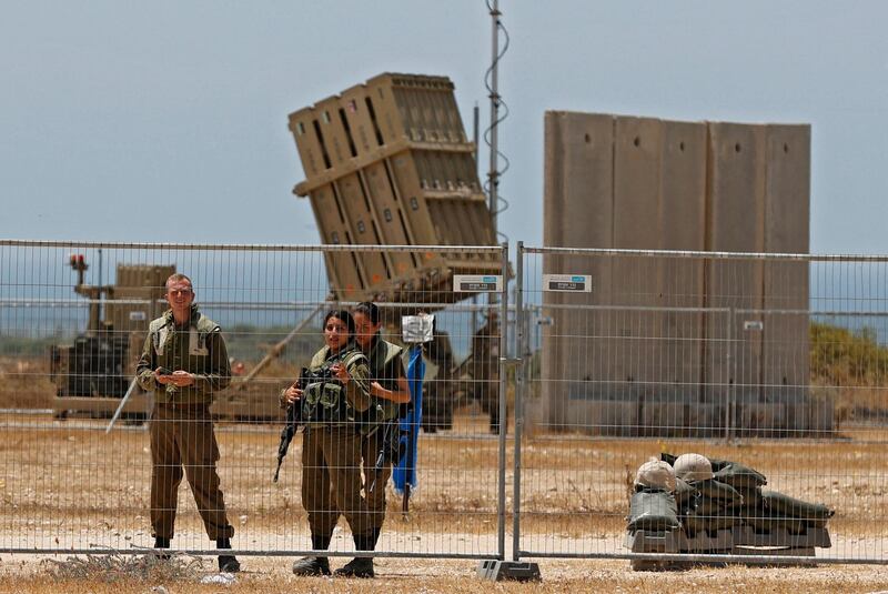 Israeli soldiers stand next to a Iron Dome aerial defence system set to intercept rockets launched from the Gaza Strip. AFP