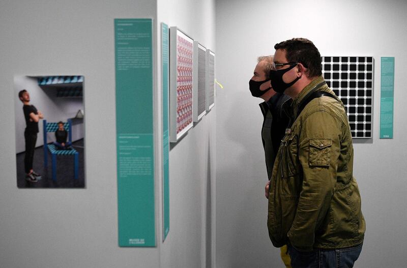 Two visitors wearing protective masks visit the Museum of Illusion in Paris. AFP