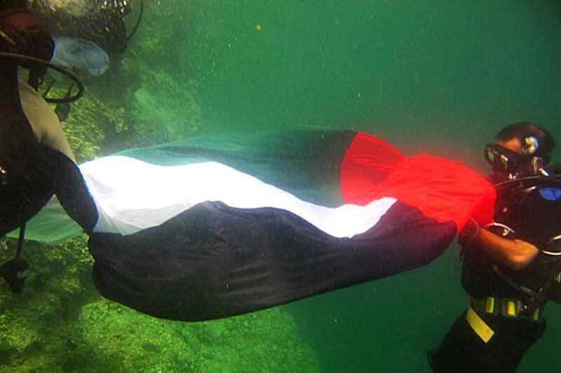 The UAE flag under water off the coast of Ajman.