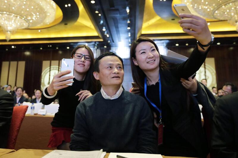 Female delegates take "selfies" with Alibaba Group executive chairman Jack Ma as he arrives for the Fifth Conference of Zhejiang Chamber of Commerce in Beijing, December 6, 2014. Ma was awarded Honorary Chairman of Zhejiang Chamber of Commerce during the conference. Jason Lee / Reuters