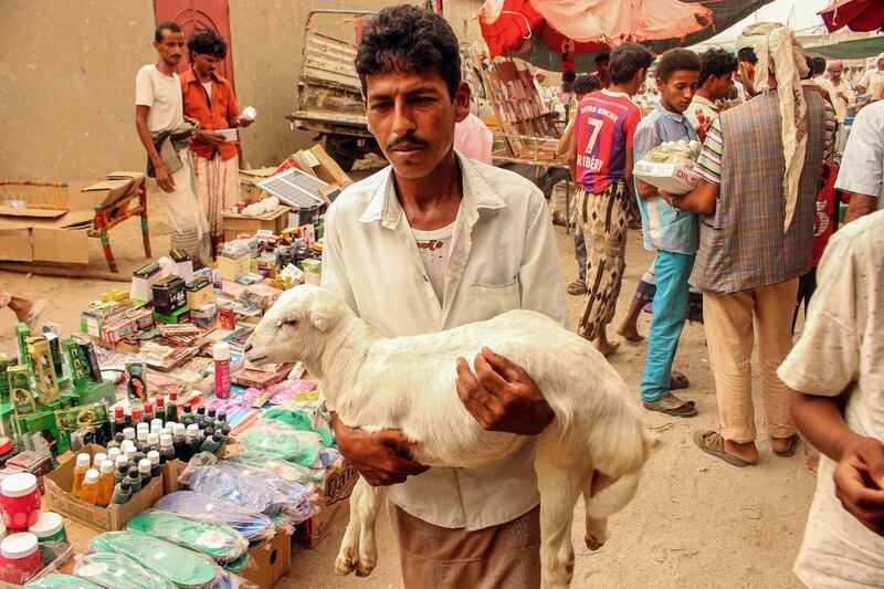 A Yemeni man carries a lamb at a market in Yemen's northwestern Hajjah province. AFP