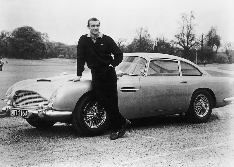 James Bond star Sean Connery stands with the Aston Martin DB5 on the set of 'Goldfinger' in 1964