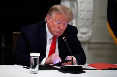 President Donald Trump looks at his phone during a roundtable with governors in the State Dining Room of the White House in Washington, June 18, 2020. AP