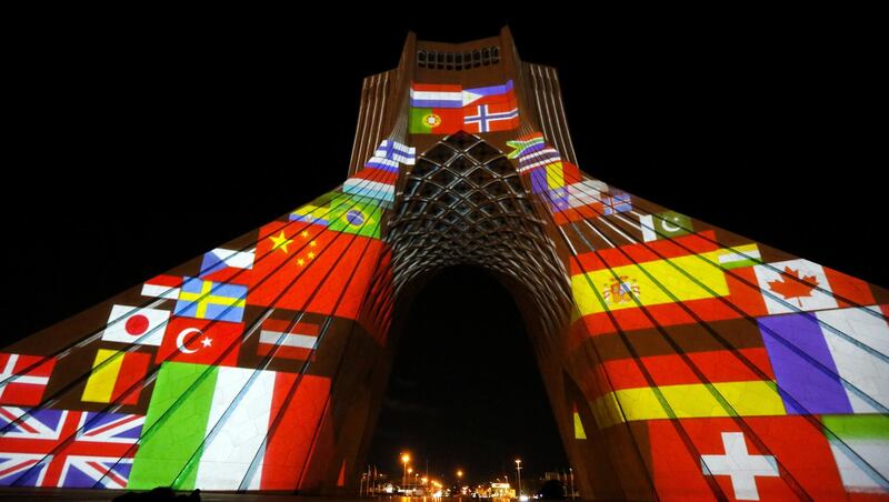 Iran's Azadi (Freedom) Tower is lit up with flags and messages of hope in solidarity with all the countries affected by the COVID-19 coronavirus pandemic, in Tehran on March 31, 2020. (Photo by - / AFP)