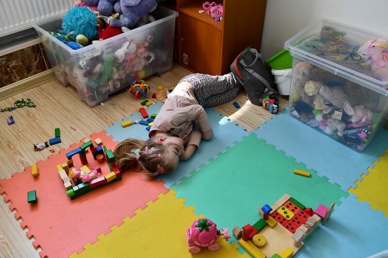 A girl from Ukraine rests on the floor in the Budapest hostel for refugees. AP