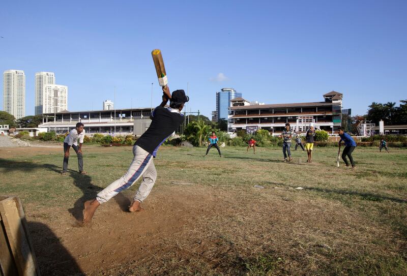 Boys play cricket at Mahalaxmi Race course in Mumbai, India on May 28, 2013 as the grand stand is seen in the background.
(Photo by Kuni Takahashi)