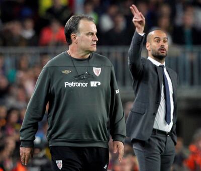 FILE PHOTO: Barcelona's coach Pep Guardiola (R) and Athletic Bilbao's coach Marcelo Bielsa react during their Spanish First division soccer league match at Camp Nou stadium in Barcelona, March 31, 2012. REUTERS/Albert Gea/File Photo