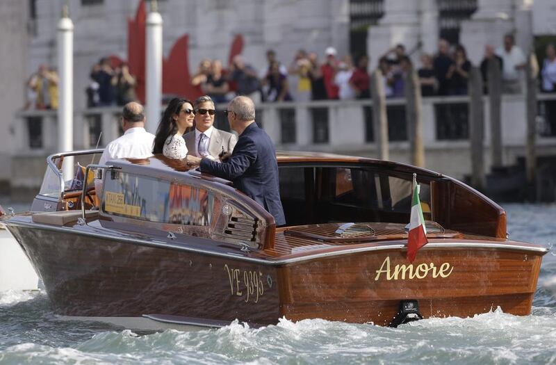 George Clooney and wife Amal cruise the Grand Canal in Venice. AP 