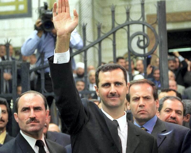 (FILES) In this file photo taken on July 17, 2000, Syria's new President Bashar al-Assad (C) waves to supporters outside the parliament in the capital Damascus. - President Bashar al-Assad, whose family has ruled Syria for over half a century, faces an election this week meant to cement his image as the only hope for recovery in the war-battered country, analysts say. (Photo by Louai Beshara / AFP)